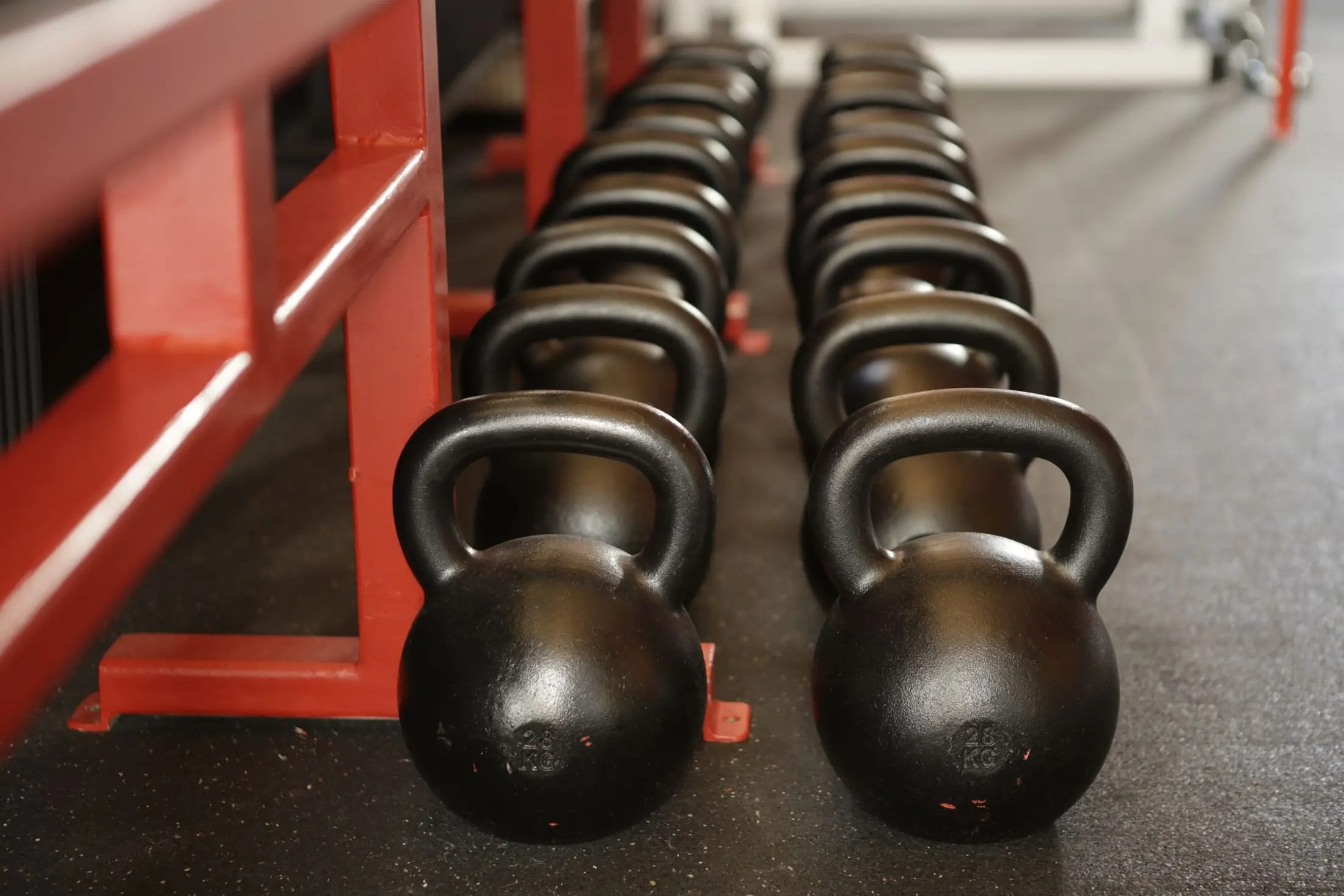 Kettlebells alineadas en el rack