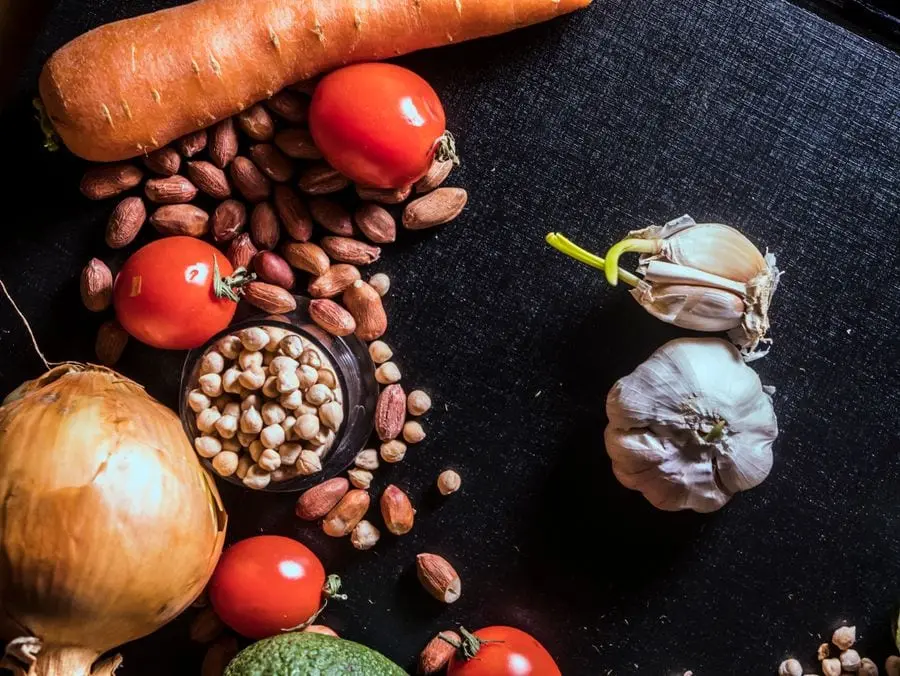 Verduras, legumbres y frutos secos sobre una mesa oscura
